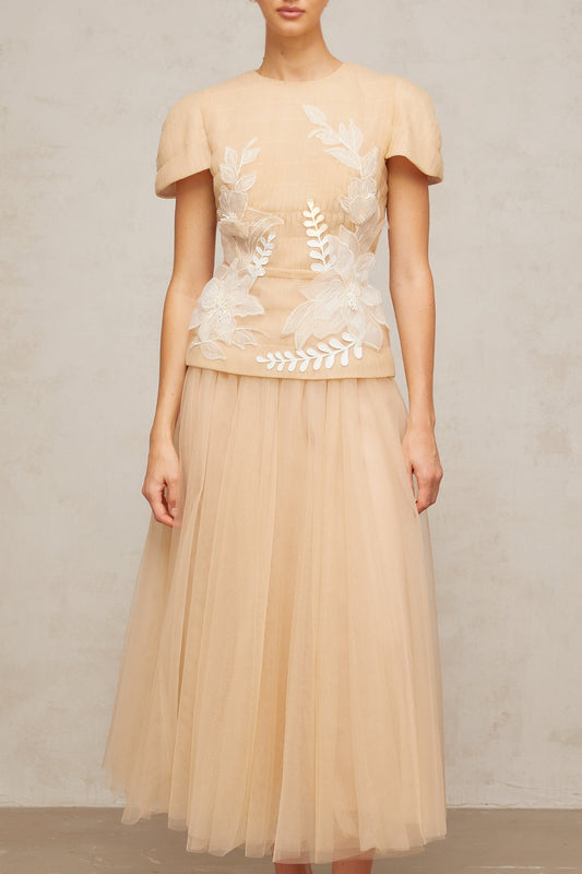 A matching set featuring a tulle top and skirt with floral applique details named Ludivine The ensemble has a delicate and feminine appearance with a sheer overlay adorned with floral embellishments
