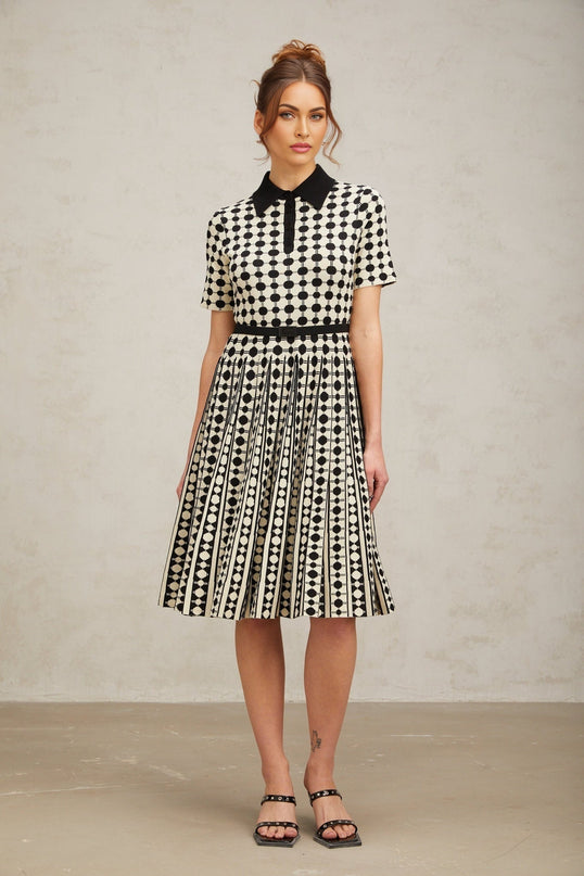 A midi dress with color blocking and polka dot patterns on a knit fabric featuring different sections in contrasting colors and prints