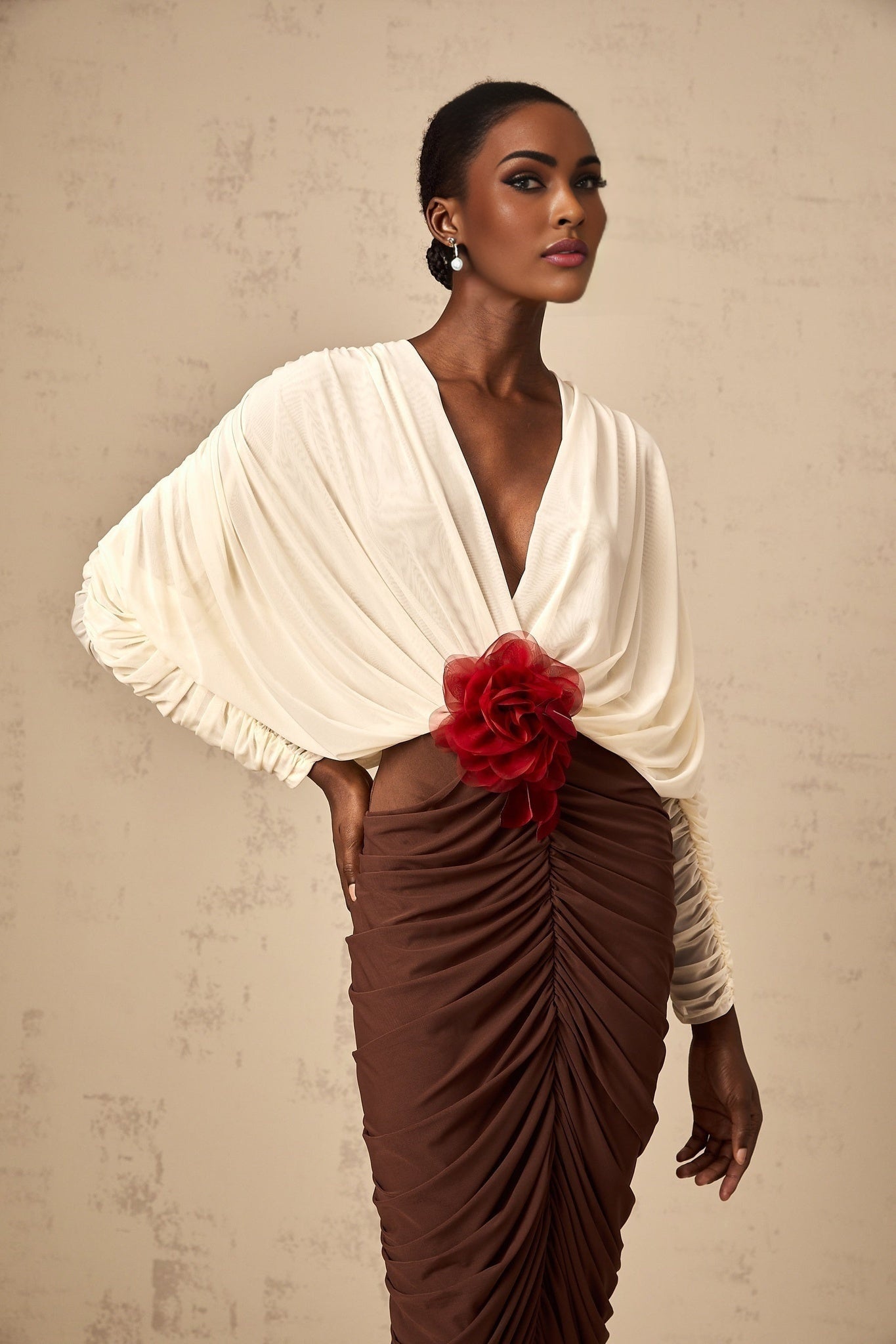 A midi dress with ruched detailing featuring color blocking and a decorative flower brooch named Leontine