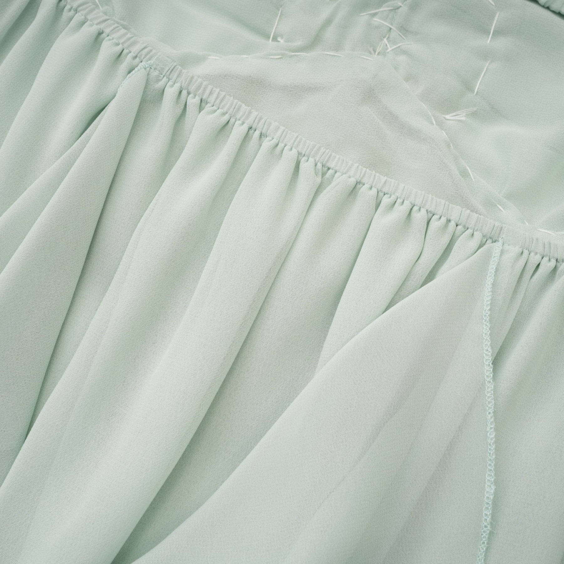 A midi dress with ruffles and embellishments called Salilah featuring a feminine silhouette and decorative details