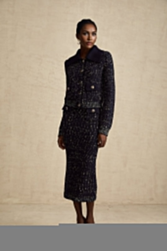 A navy blue crochet knit jacket and matching skirt set worn by a model against a plain background