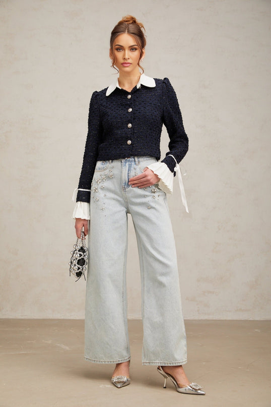 A navy blue tweed jacket with panels worn by a model against a plain background