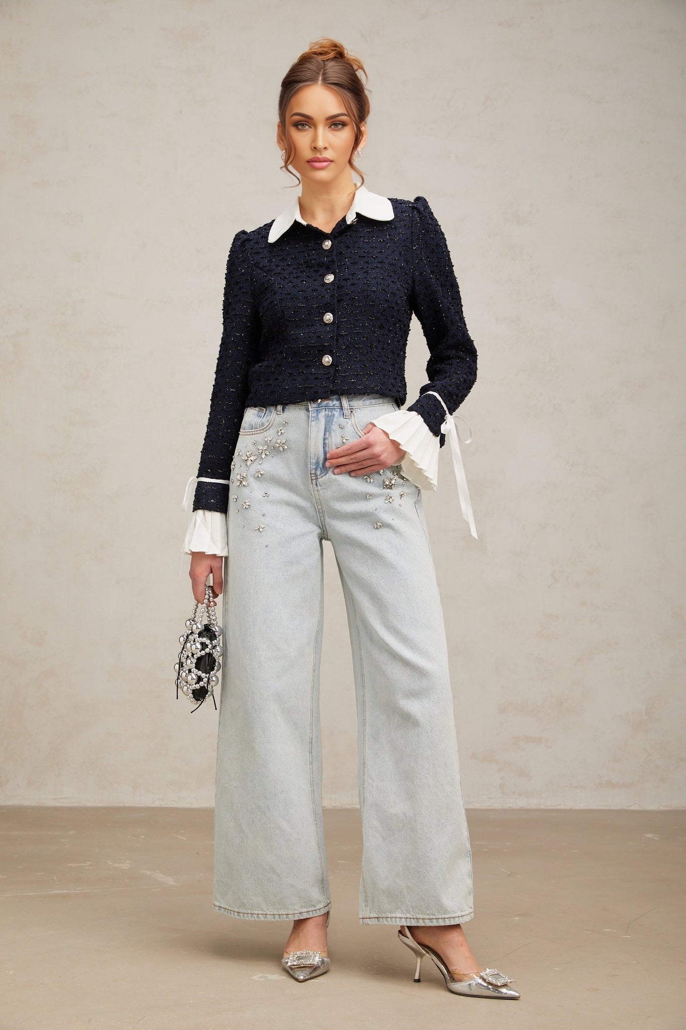 A navy blue tweed jacket with panels worn by a model against a plain background