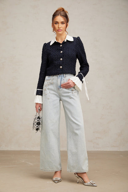 A navy blue tweed jacket with panels worn by a model against a plain background