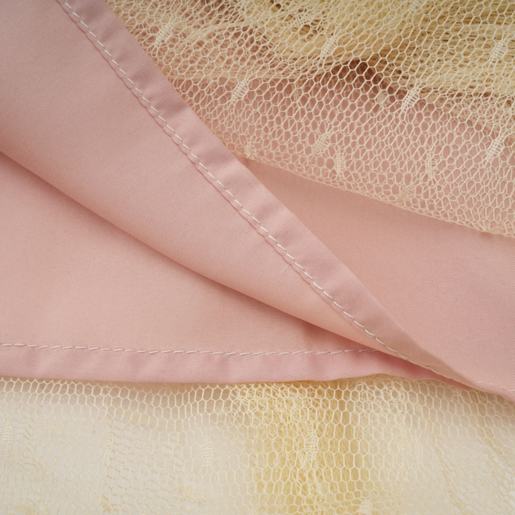 A neutral colored midi dress with floral lace paneling and tulle fabric featuring a delicate and feminine design