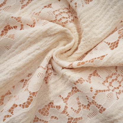 A neutral colored mini dress with floral lace pattern and flared cuffs named Émeline