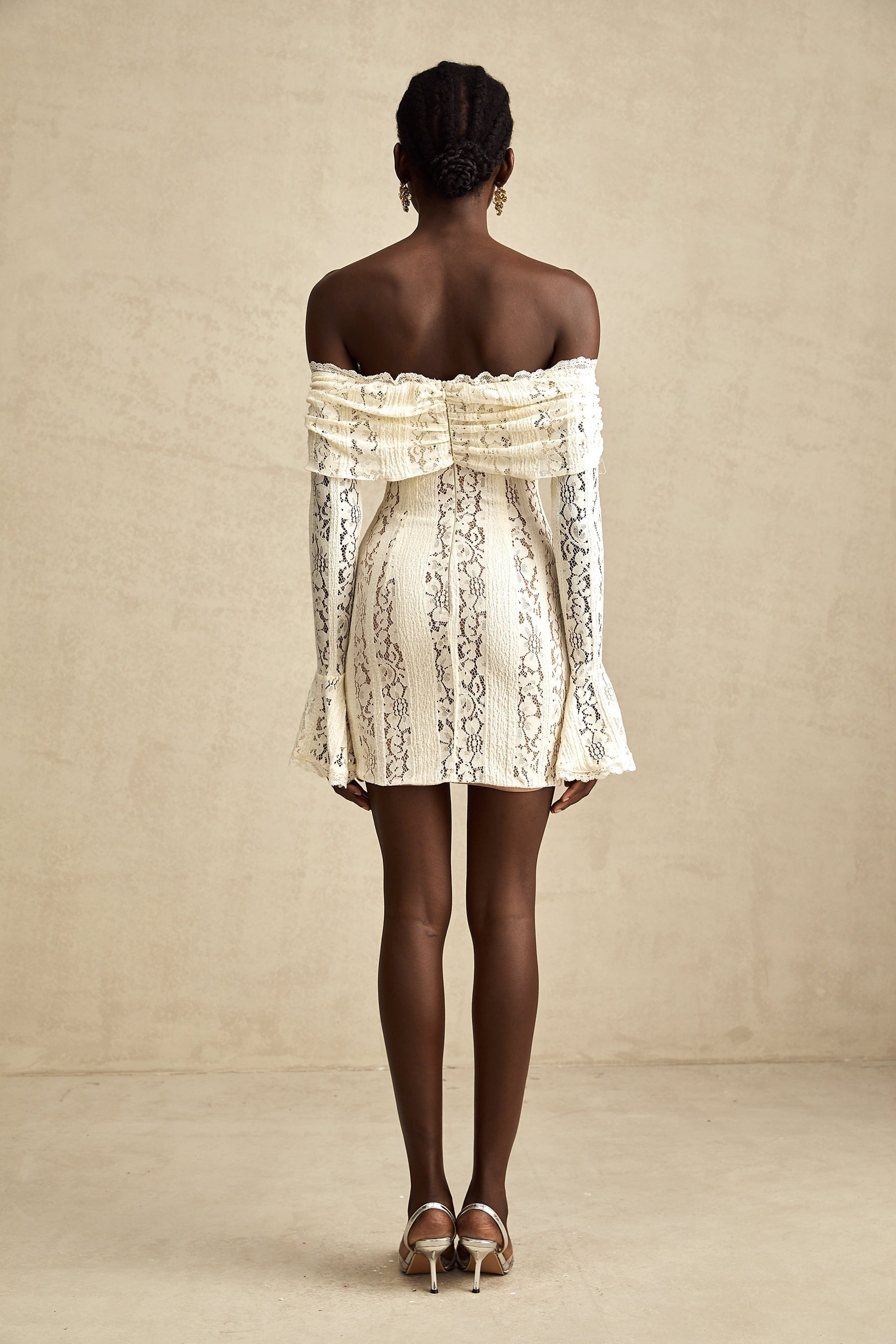 A neutral colored mini dress with floral lace pattern and flared cuffs named Émeline