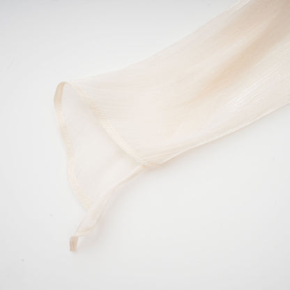 A neutral colored mini dress with full pleats and ruffles named Eugenie featuring a short hemline and feminine design