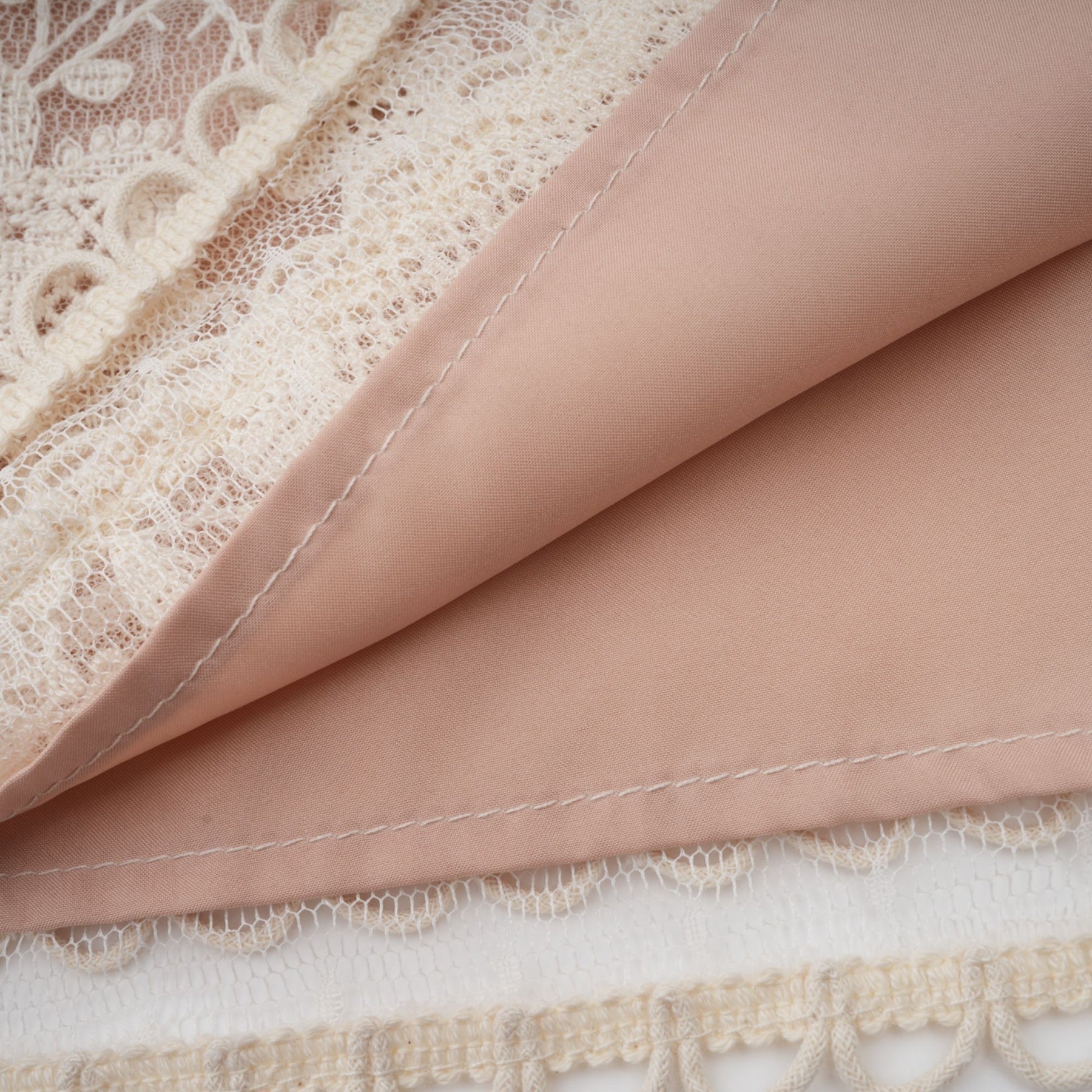 A neutralcolored midi dress with floral embroidery and lace details featuring a delicate fleur pattern