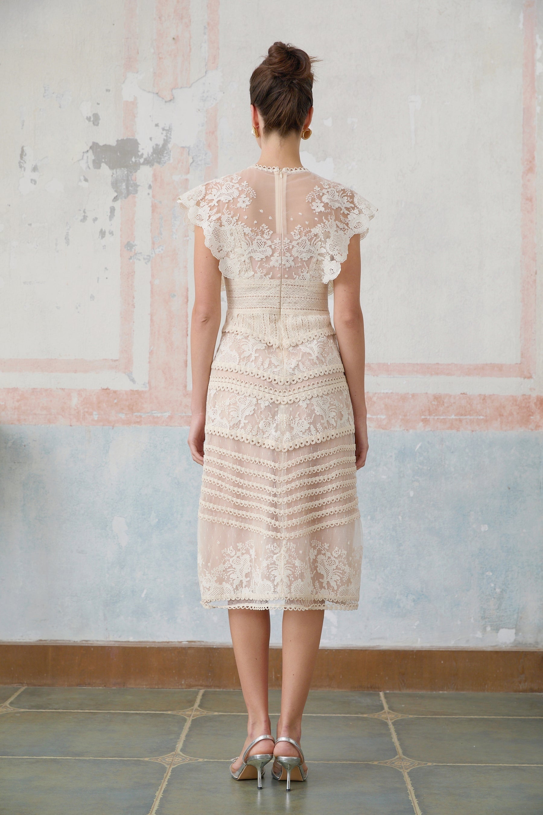 A neutralcolored midi dress with floral embroidery and lace details featuring a delicate fleur pattern