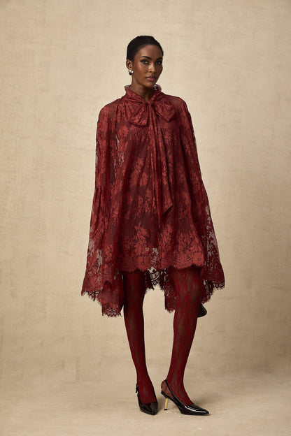 A pair of red tights with floral lace cutout patterns visible on the legs