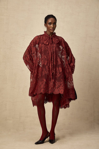 A pair of red tights with floral lace pattern and cut out details on display