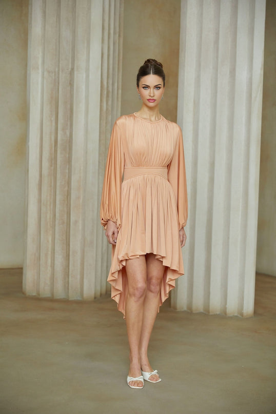 A pink asymmetrical midi dress with pleated details featuring a flowing skirt and sleek silhouette