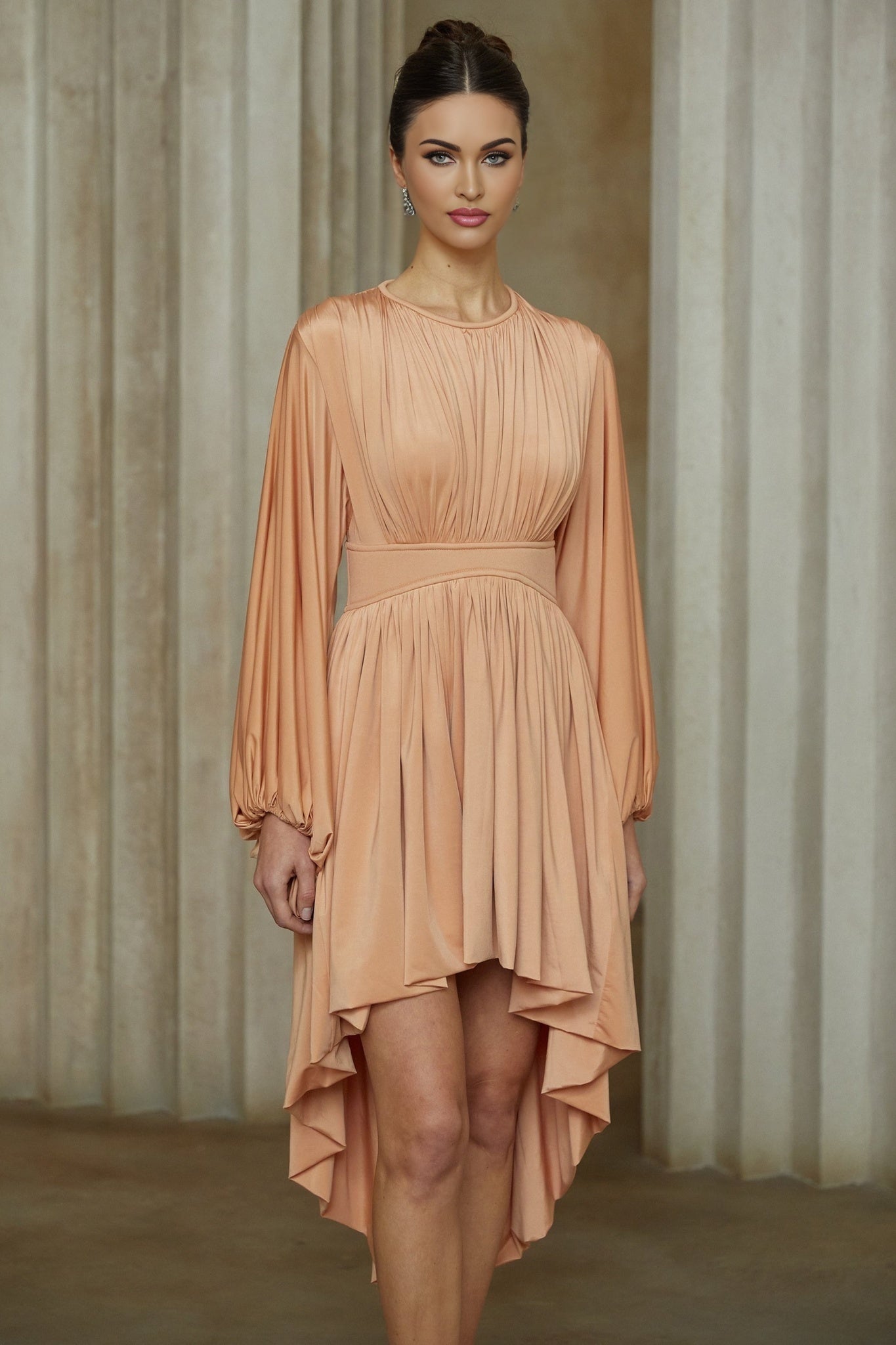A pink asymmetrical midi dress with pleated details featuring a oneshoulder design and flowing skirt
