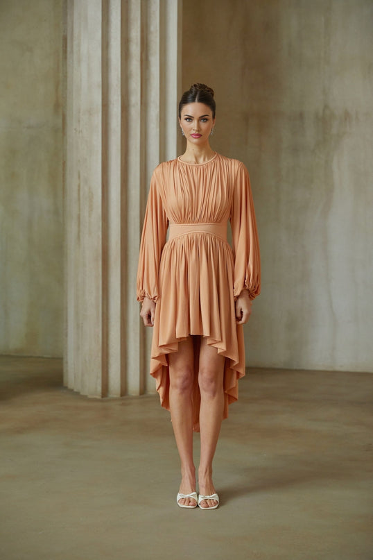 A pink asymmetrical midi dress with pleated details featuring a sleeveless design and a flowy silhouette