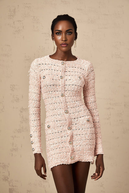A pink fitted knit mini dress on a mannequin or model showcasing its formfitting silhouette and short length