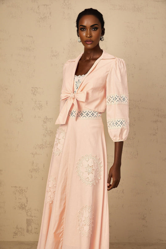 A pink floral blouse and dress set featuring embroidered details The blouse has short sleeves and the dress has a matching floral pattern Both pieces are designed for a young girl and have a feminine and delicate appearance