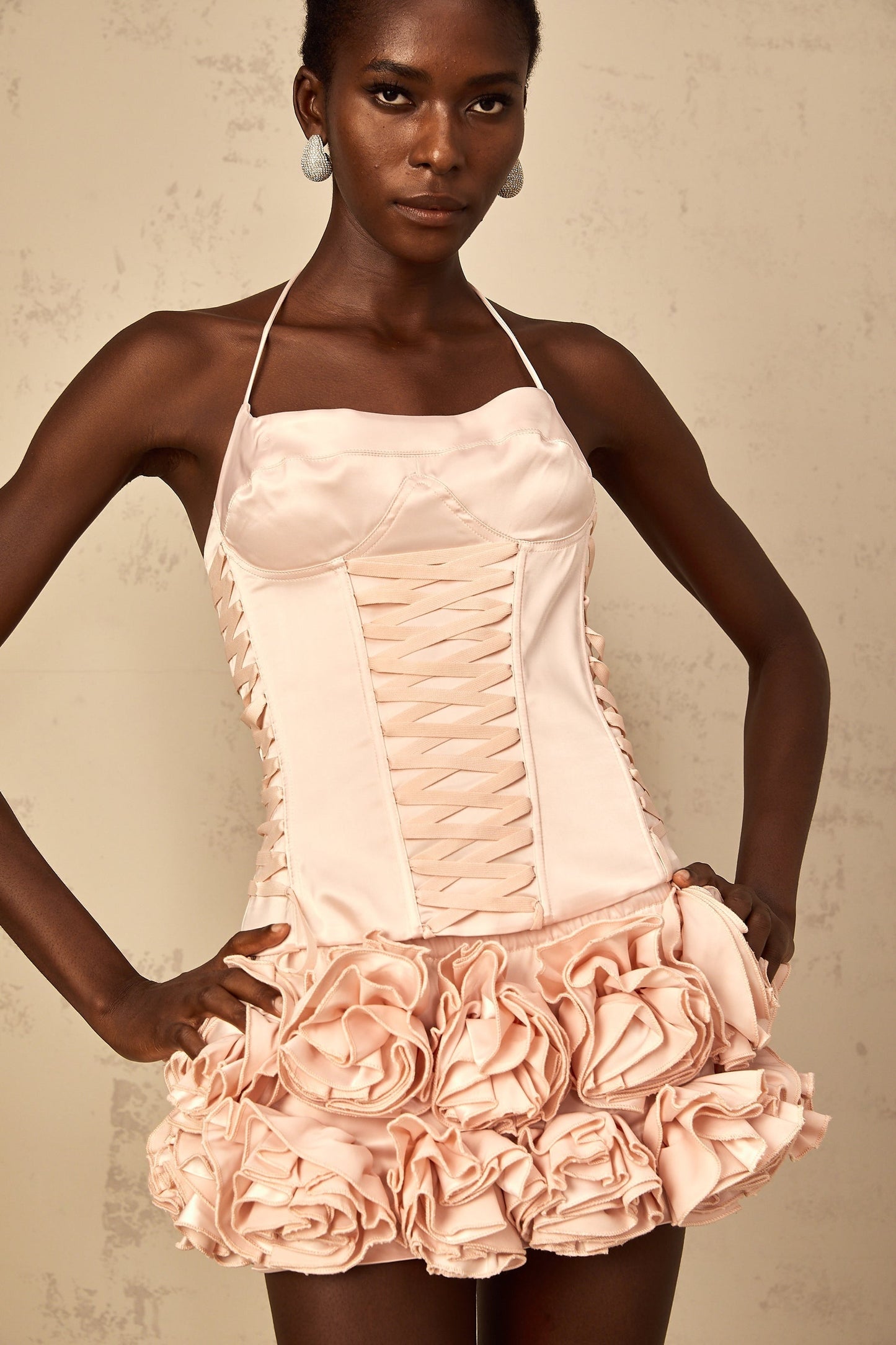 A pink matching set consisting of a lace up top and skirt adorned with faux flowers feminine and floral outfit combination