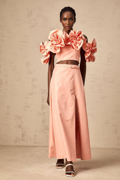 A pink matching set featuring a top and skirt with floral applique details