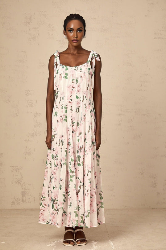 A pink maxi dress with a floral print pattern and tied straps
