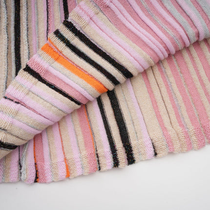 A pink metallic midi dress with pleats named Mathilde featuring a shimmering fabric and a flowy silhouette that falls to mid calf length