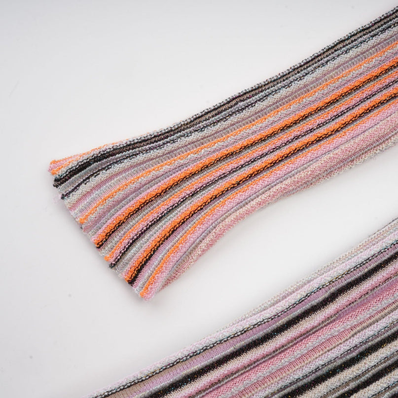 A pink metallic pleated midi dress with a feminine silhouette named Mathilde hanging on a plain background