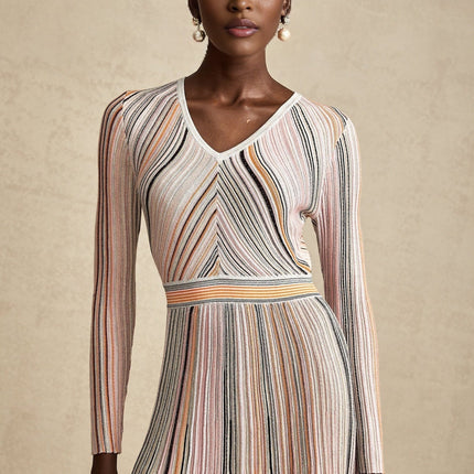 A pink metallic pleated midi dress with a shimmering finish named Mathilde featuring a flowing skirt that falls to mid calf length