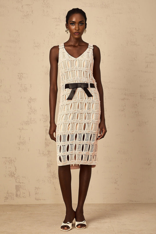 A pink midi dress with a crochet knit pattern and a decorative bowknot detail