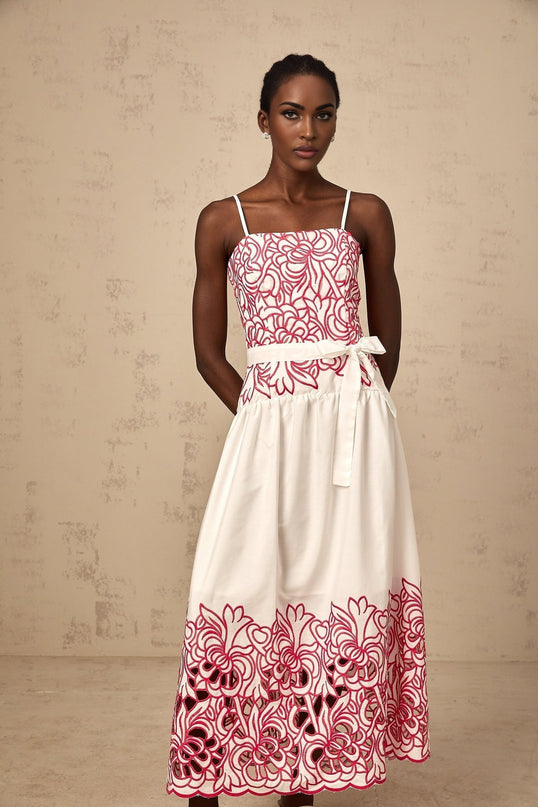 A pink midi dress with embroidered details and cutout sections featuring a feminine design named Beatrice