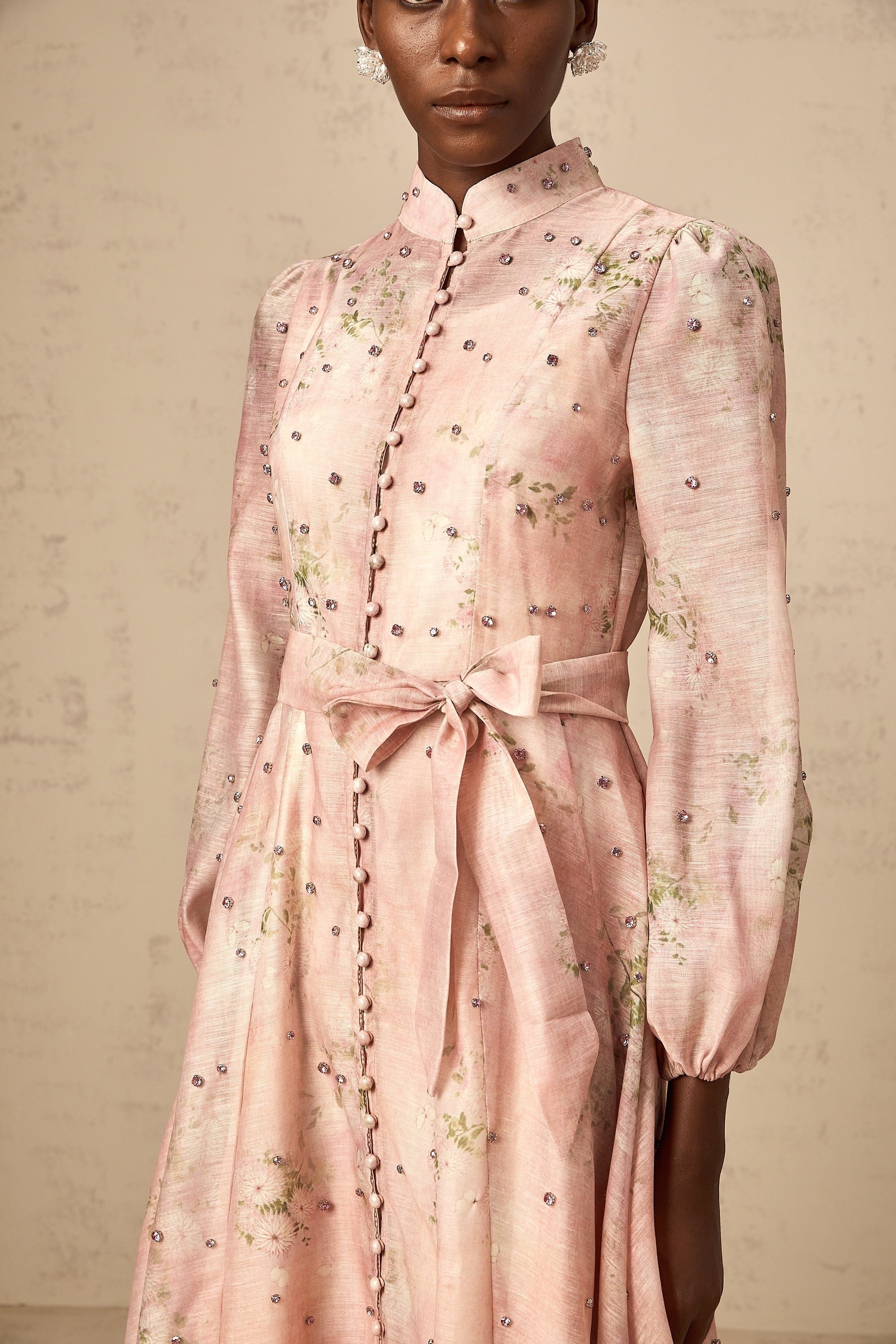 A pink midi dress with floral print and embellishments featuring a narcisse design