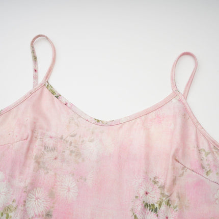 A pink midi dress with floral print and embellishments featuring a narcissusinspired design