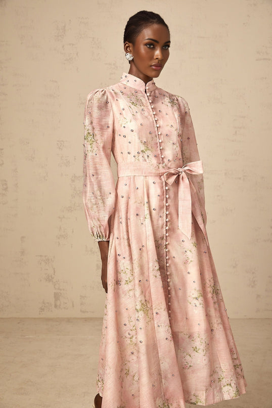 A pink midi dress with floral print pattern and embellished details featuring a Narcisse design