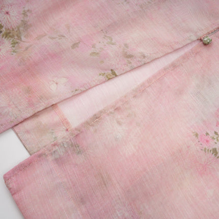 A pink midi dress with floral print pattern and embellished details featuring the Narcisse design