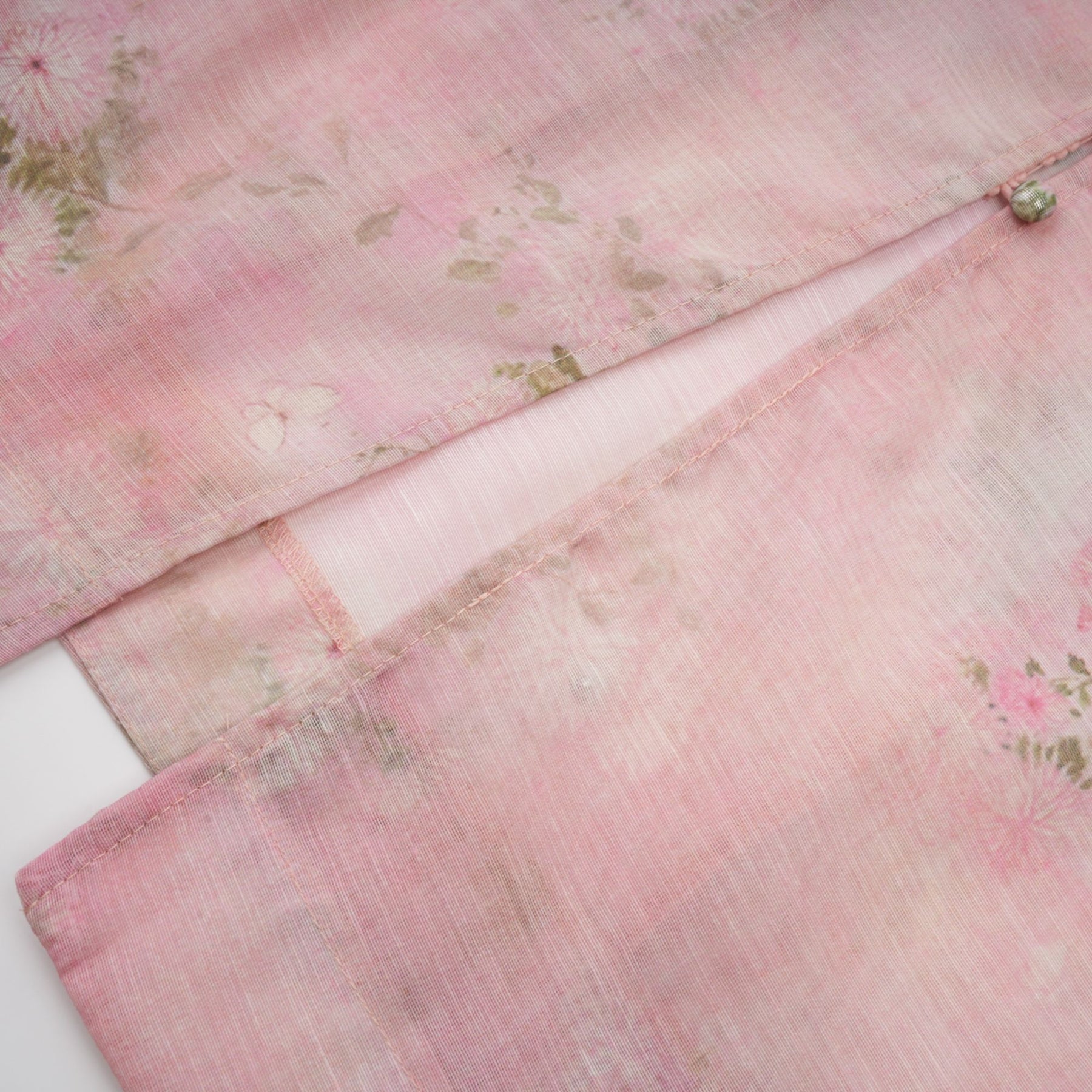 A pink midi dress with floral print pattern and embellished details featuring the Narcisse design