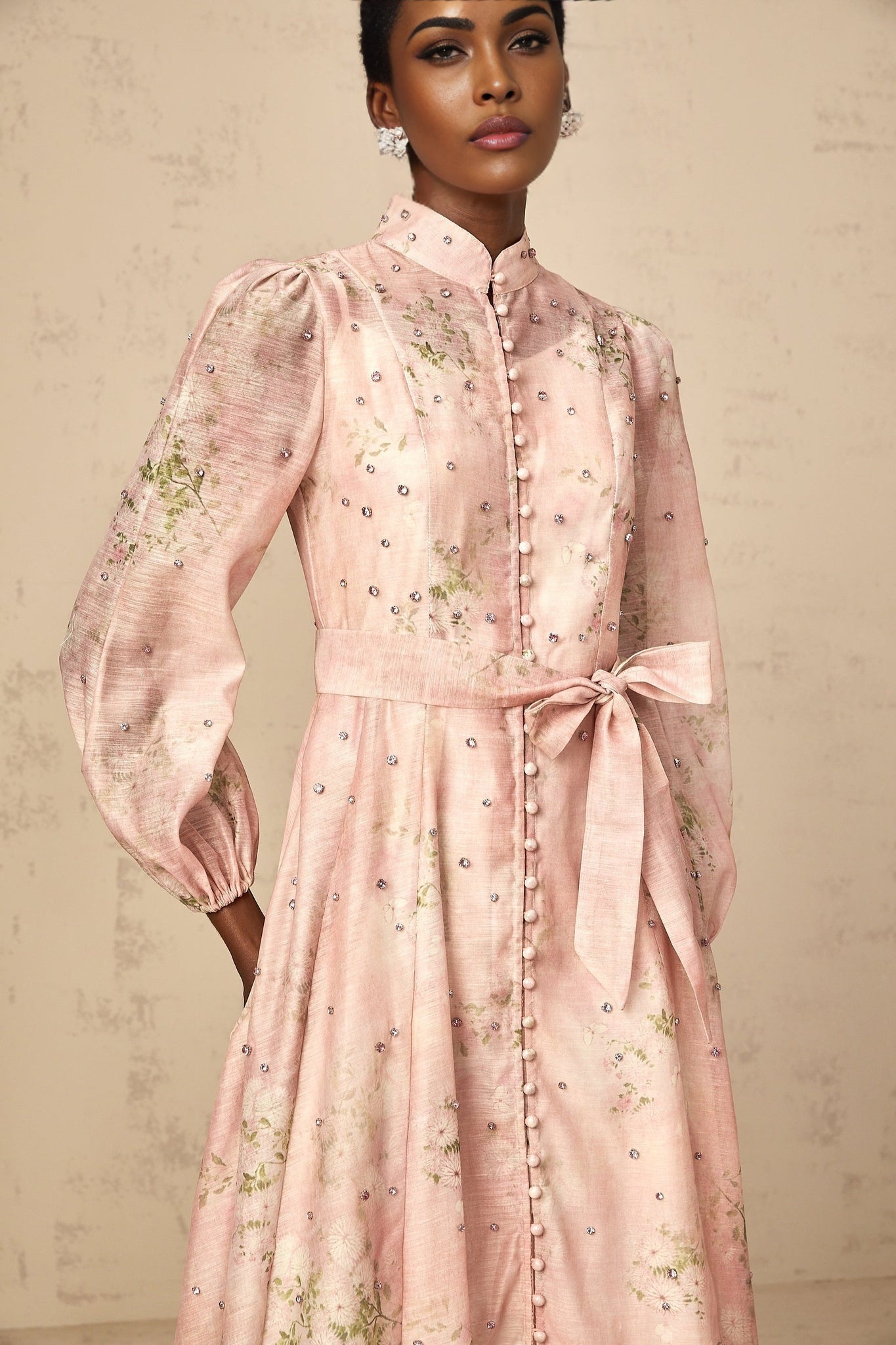 A pink midi dress with floral print pattern and embellishments featuring a design inspired by narcissus flowers