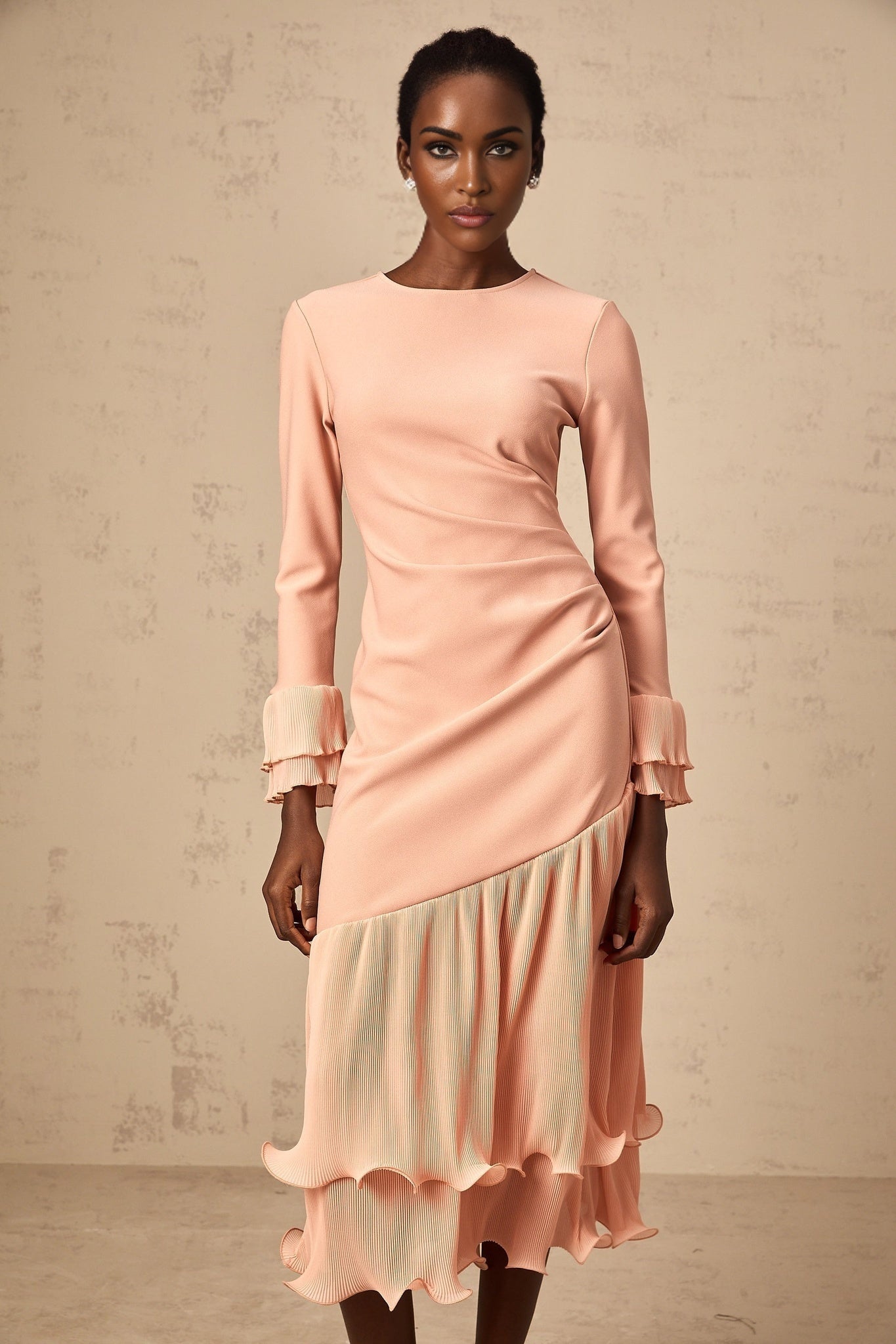 A pink midi dress with ruffled trim and paneled design featuring a flared silhouette and feminine details