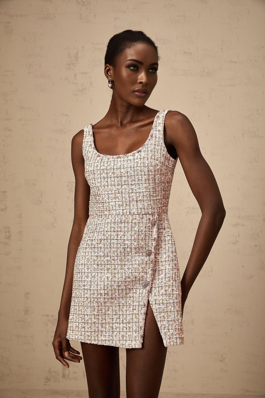 A pink mini dress made of tweed fabric with embellishments featuring a classic design and feminine silhouette