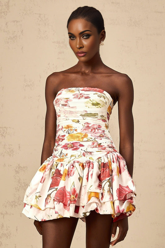 A pink mini dress with a floral print pattern and smocked detailing named Ines