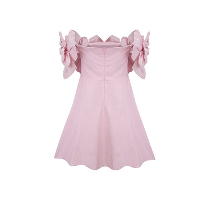 A pink mini dress with an offshoulder neckline featuring three dimensional floral petal details named Juliette