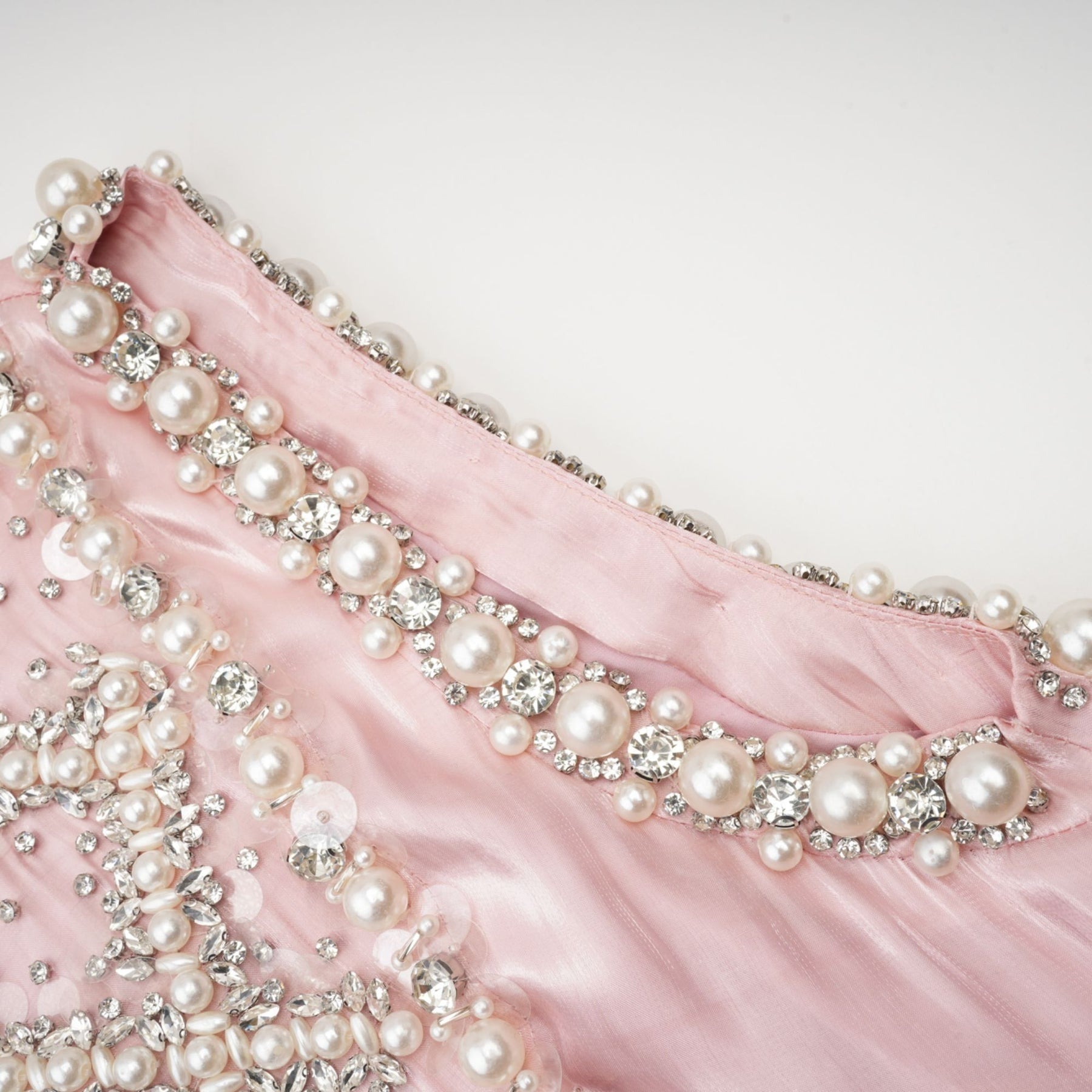 A pink mini dress with pleated skirt and embellished details named Helena