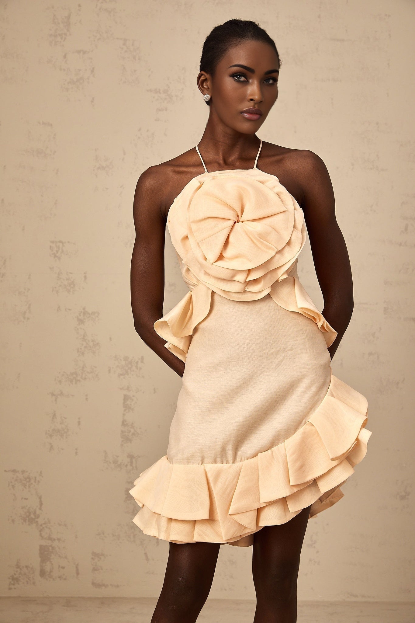 A pink mini dress with ruffled 3d petal details and a short hemline named Ginevra