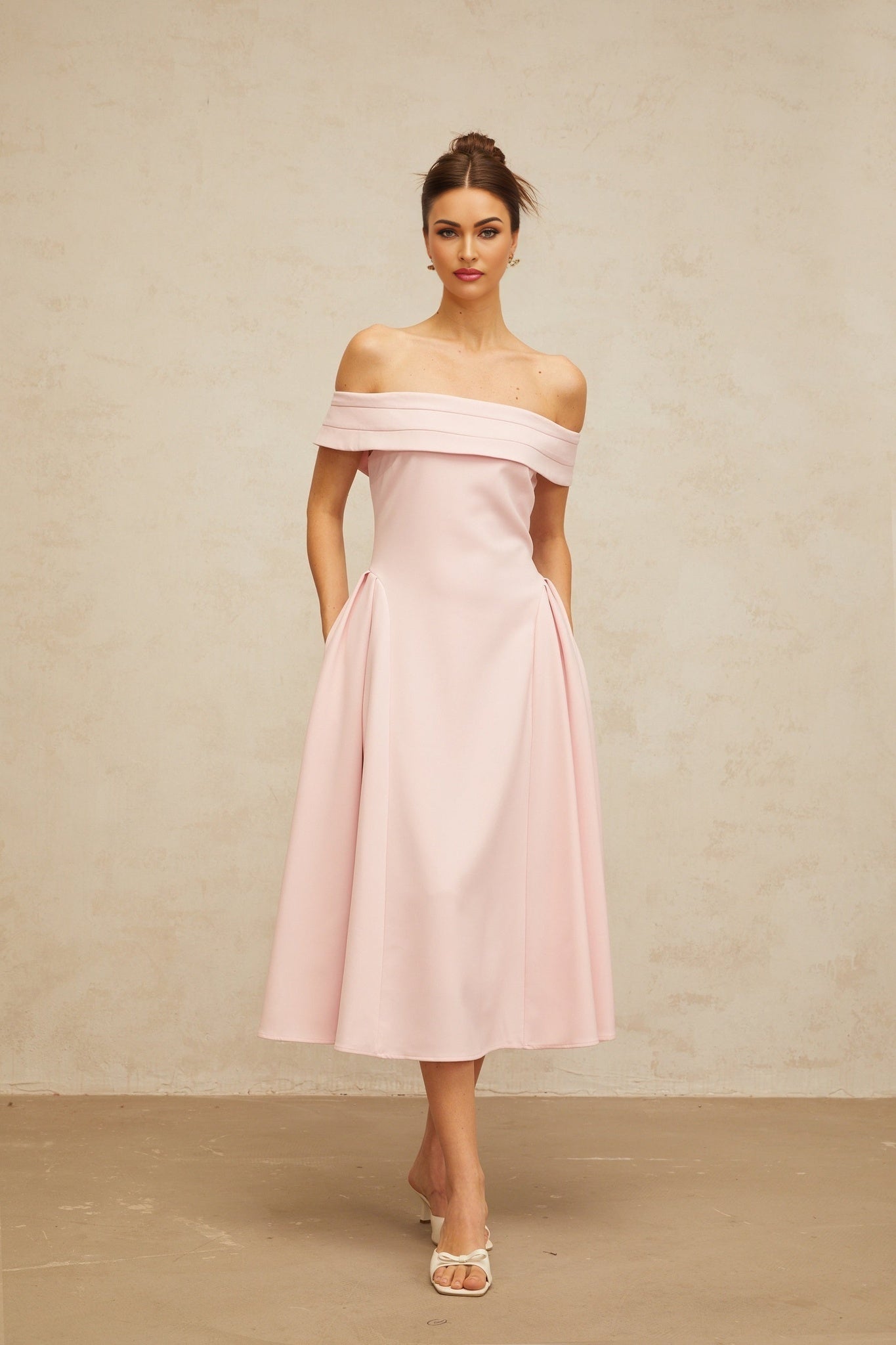 A pink off shoulder midi dress with pleated details and a fitted waist named Zelie