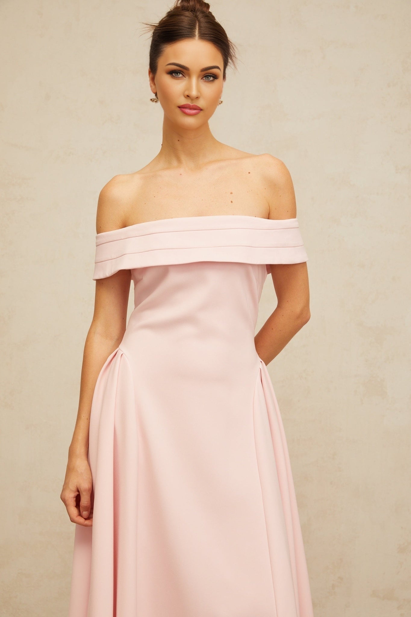 A pink off shoulder midi dress with pleated details and a flowy silhouette