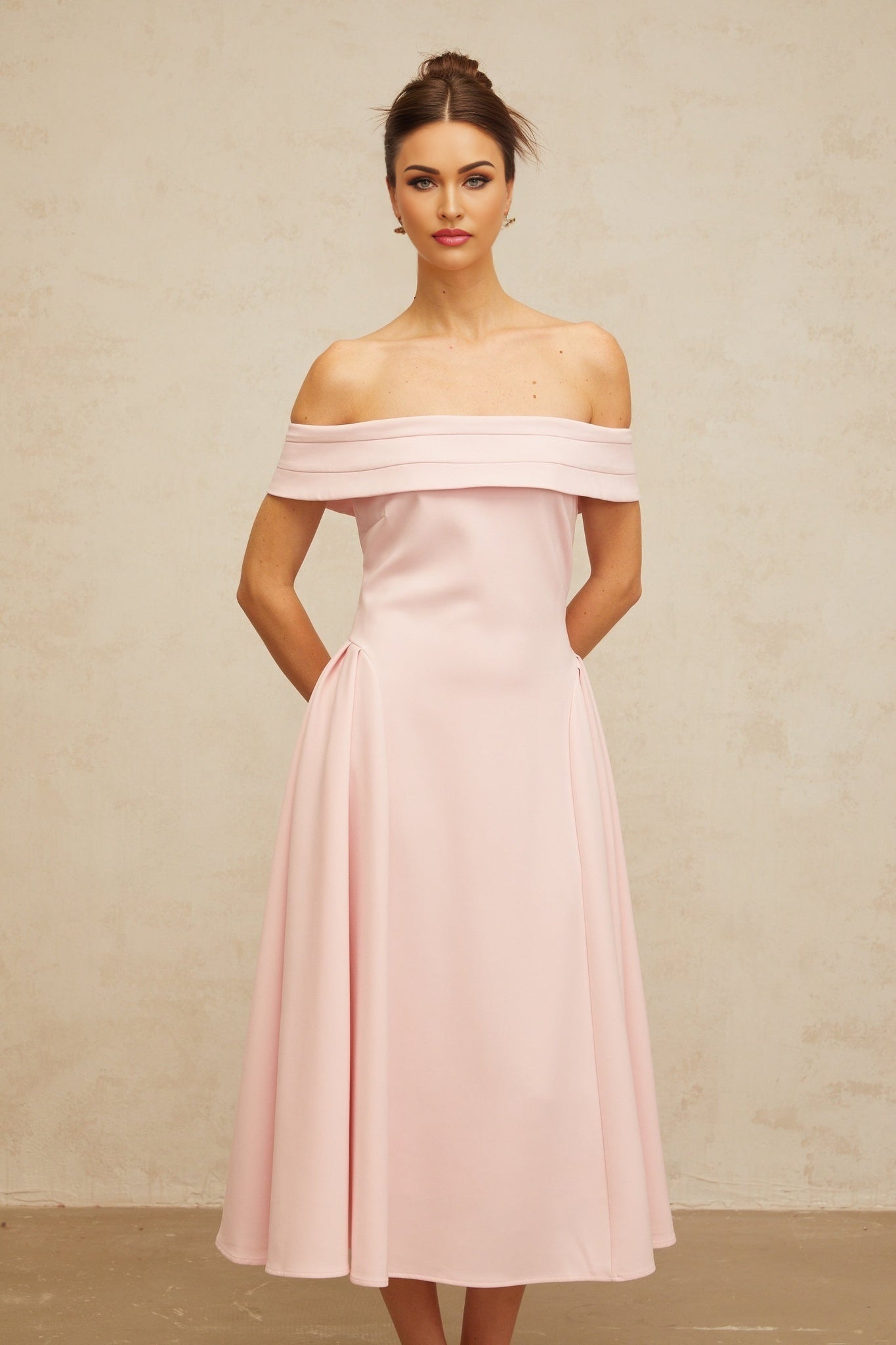 A pink off shoulder midi dress with pleated details and a flowy skirt