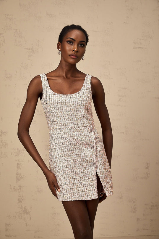 A pink tweed mini dress with embellishments named Aoife featuring a short hemline and decorative details on a textured fabric