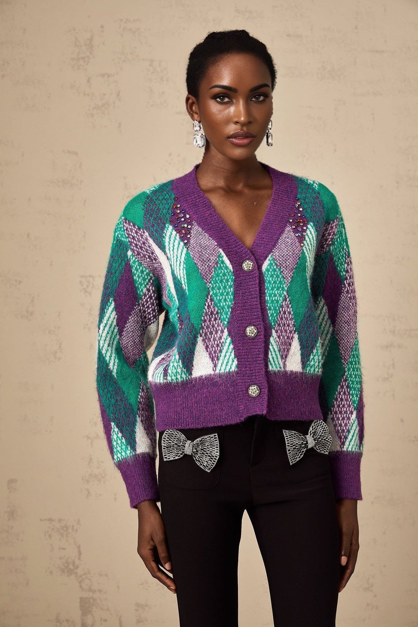 A purple knit top with an argyle pattern featuring a crewneck design and long sleeves