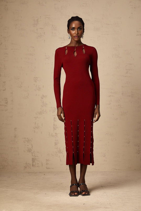 A red knit midi dress with long sleeves beaded details and cutout accents worn by a model