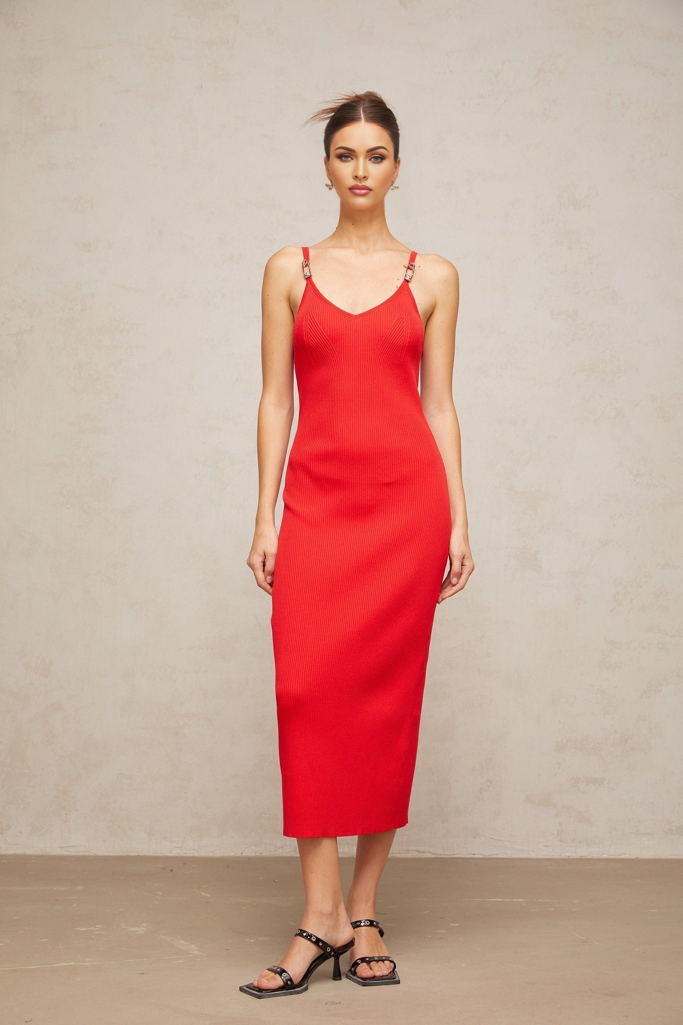 A red knitted midi dress with pin details and a fitted silhouette
