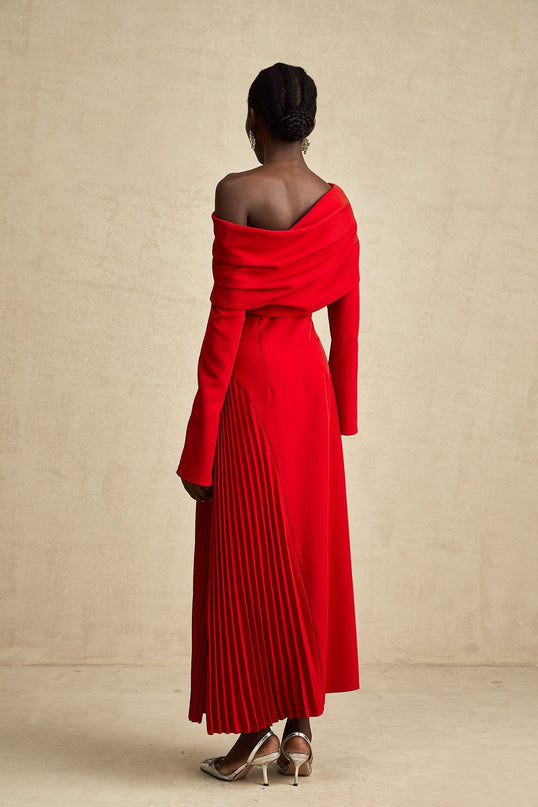 A red long pleated maxi dress with a high slit ideal for Valentines Day featuring a fitted bodice and flowing skirt