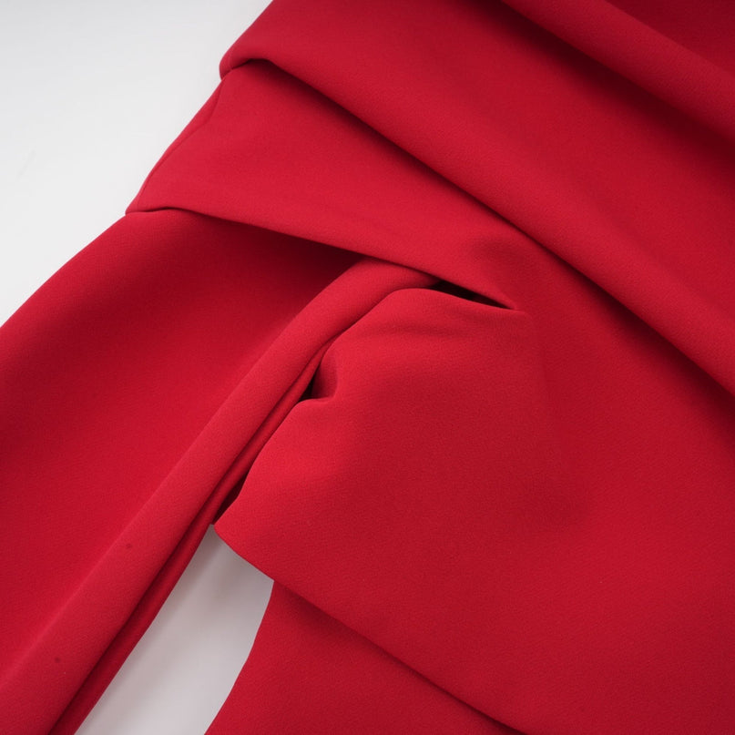 A red maxi dress with a high slit and pleated skirt perfect for Valentines Day featuring long sleeves and a flowing silhouette